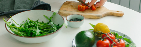 Someone chopping tomatoes, prepared salad