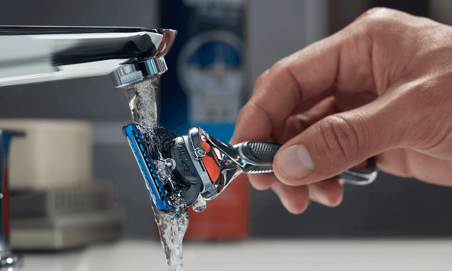 Man rinsing Gillette Fusion5 Proglide under tap.