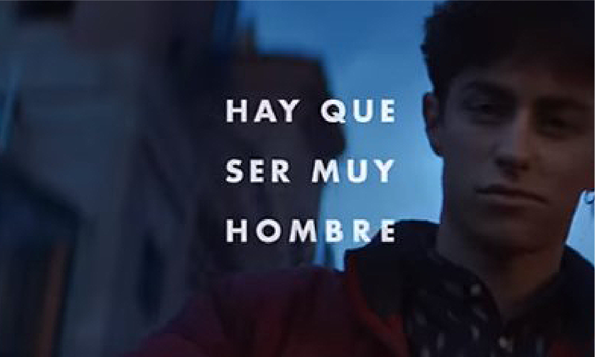 Close up of boy's face and 'Hay Que Ser Muy Hombre' (it takes a real man) text