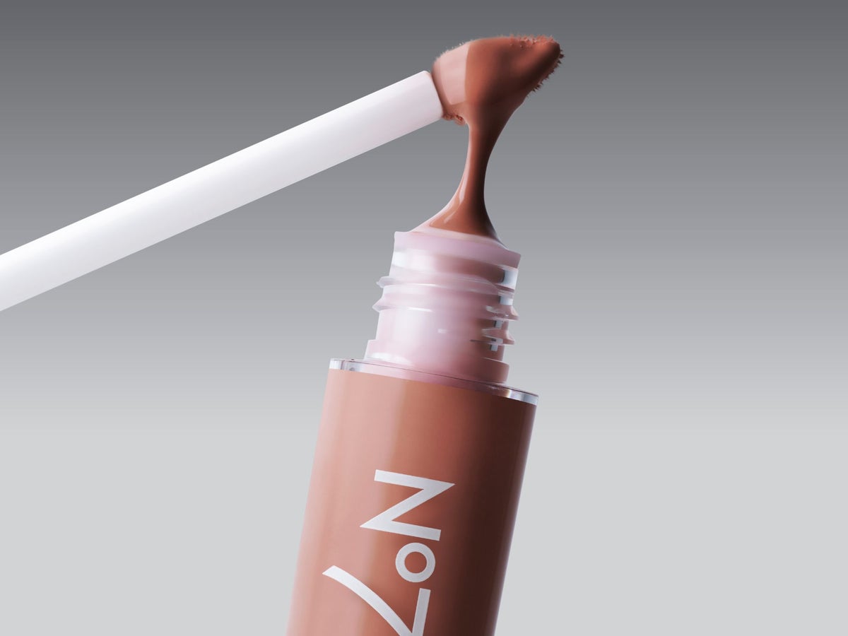 No7 Pro Artist Lip Shine dripping onto the lip gloss tube in front of a grey background