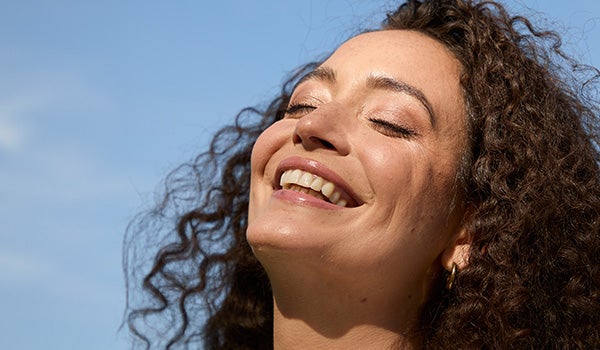 A model smiling in front of a grey background