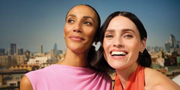 Two women smiling on a rooftop