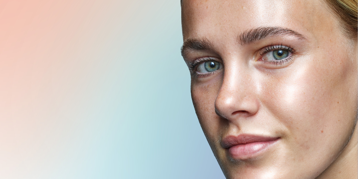 Pastel colour ombre background in shades of pink, purple and blue. Close up shot of a model showing the glass skin look.