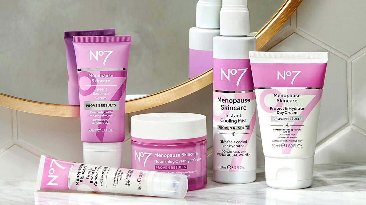 Four products in the No7 Menopause skincare line on a black countertop