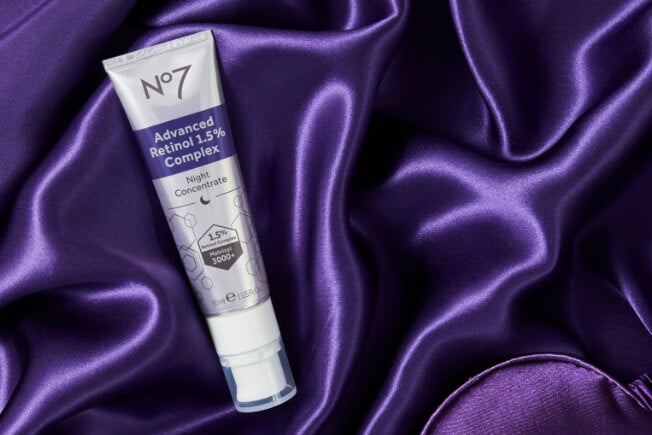 Tube of No7 Advanced Retinol 1.5% Complex Night Concentrate on a purple velvet sheet