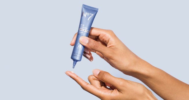 Hand applying No7 Lift & Luminate Triple Action Serum to a finger