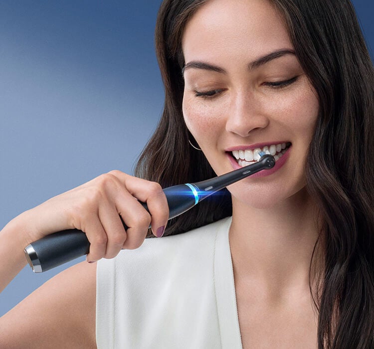Women Brushing Teeth with iO Electric Toothbrush
