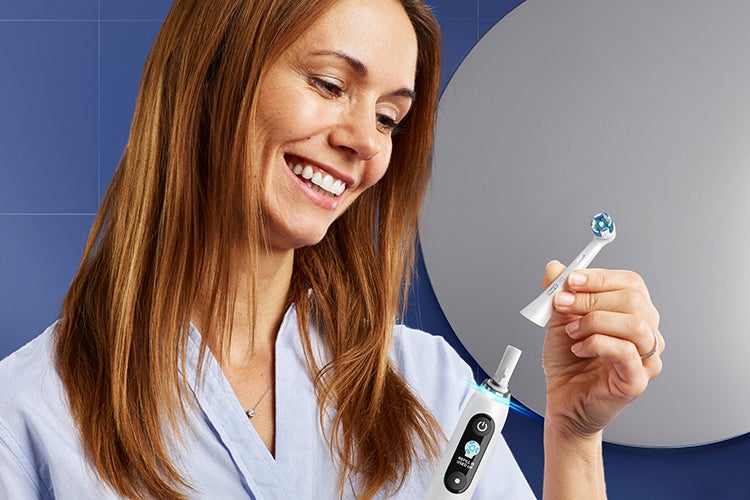 Woman holding Oral-B iO Electric Toothbrush