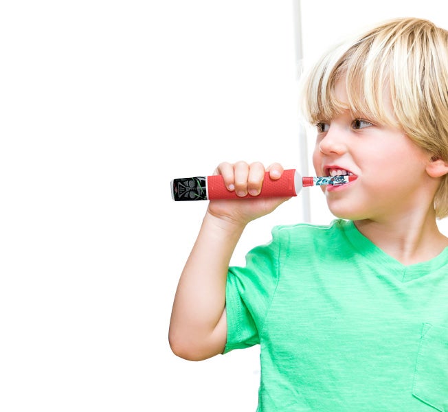 A boy using kids toothbrush