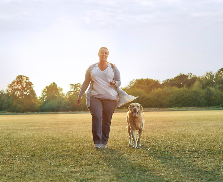 Image of Woman walking her dog in the park