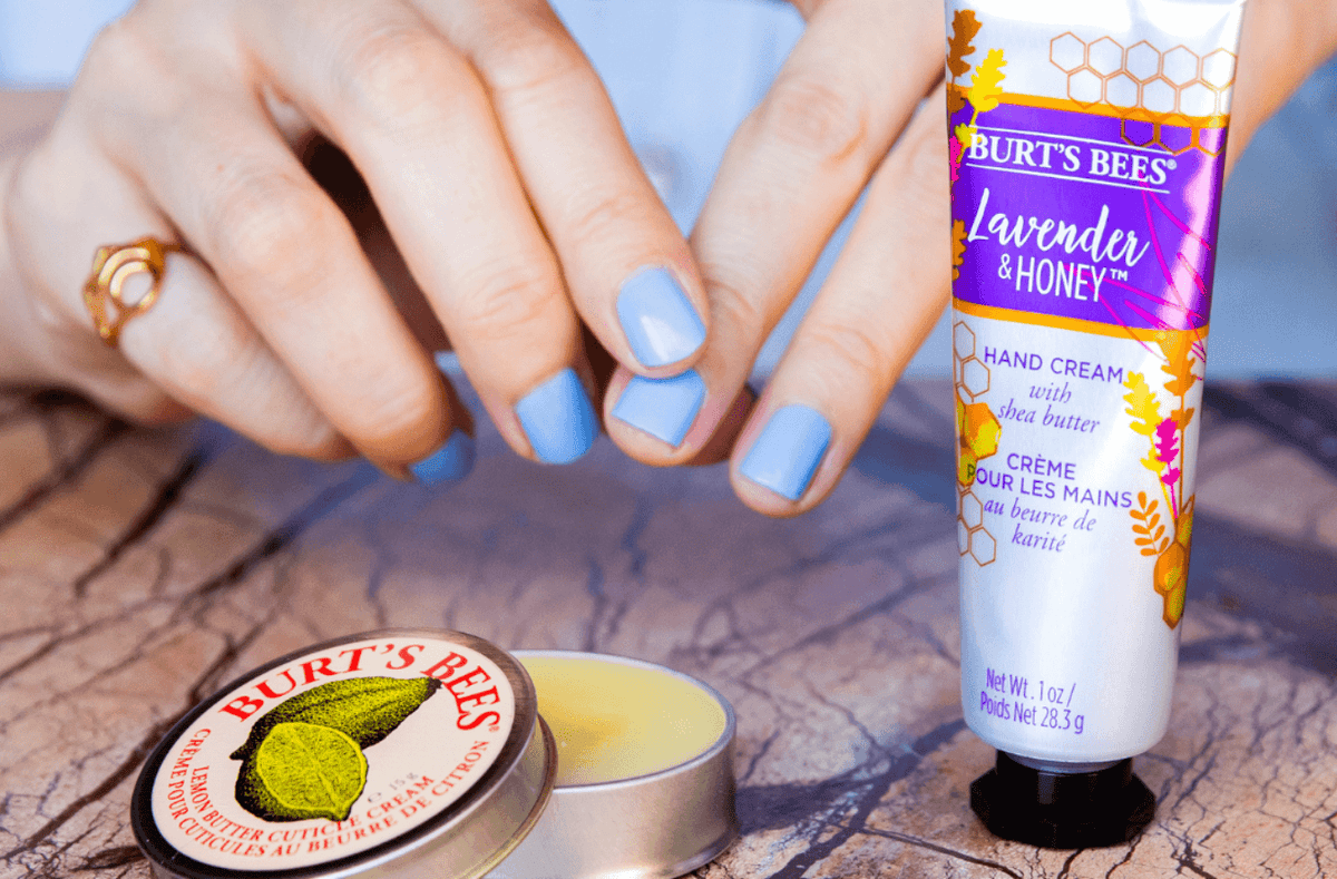 Jasmine Hemsley massaging in the Burt's Bees Lemon Cuticle Cream into her nails next to a bottle of Lavender and Honey Shea Butter Hand Cream