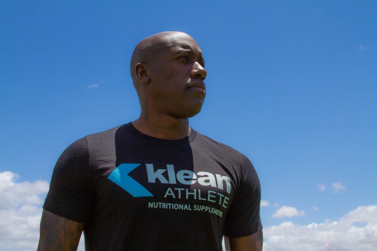 A man wearing klean athlete nutritional supplements t-shirt
