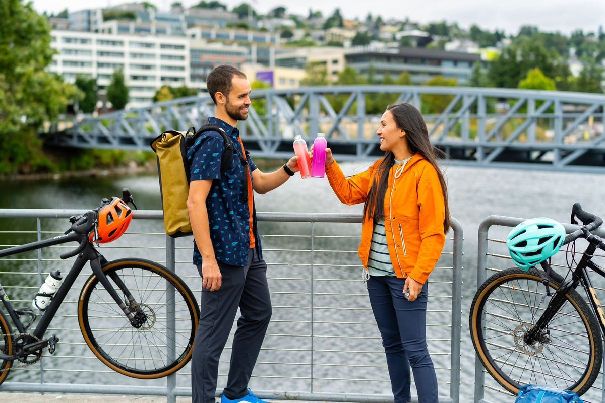 Two friends holding sports bottles with Nuun hydration inside