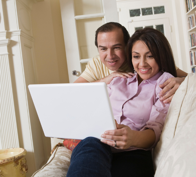 Couple looking at a white laptop