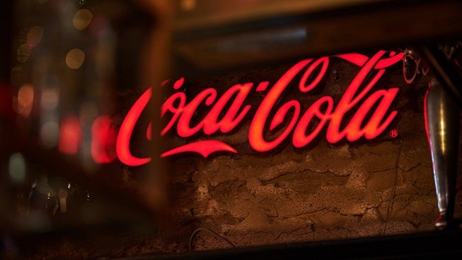 Coca-Cola logo on a wood background