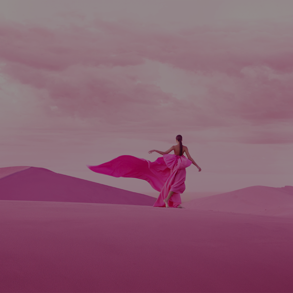 Woman in pink dress walking in the desert
