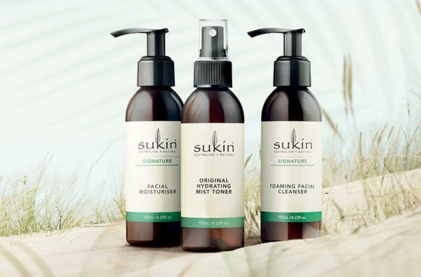 3 Sukin products on sand: Facial Moisturiser, Hydrating Mist Toner, Foaming Facial Cleanser