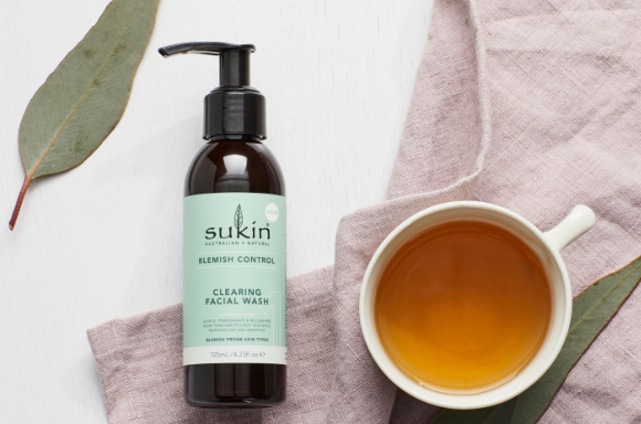 Sukin clearing facial wash with cup of tea for decoration.