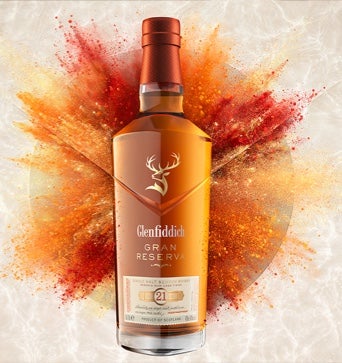 Glenfiddich Gran Reserve whisky with a pop of colourful powder in the background