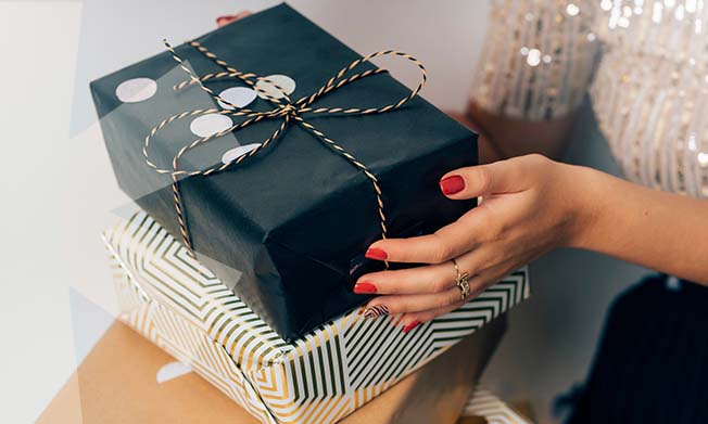 A woman holding two wrapped up boxes