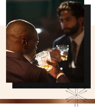 Two gentlemen in a dimly lit room drinking cocktails from glasses with a clink logo in the corner