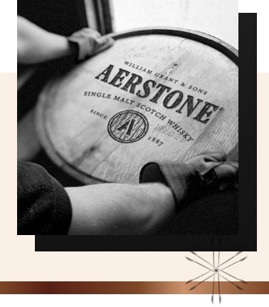 A wooden barrel of Aerstone Whiskey being picked up by someone wearing thick gloves