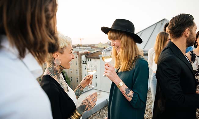 Two women laughing and holding a drink each