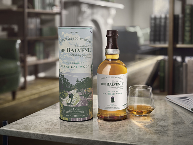Bottle of The Balvenie with is packaging and a glass of whisky next to it