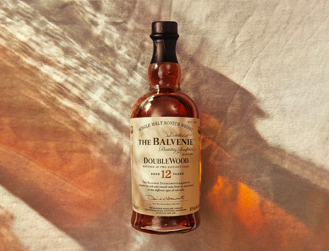 Bottle of The Balvenie with is packaging and a glass of whisky next to it
