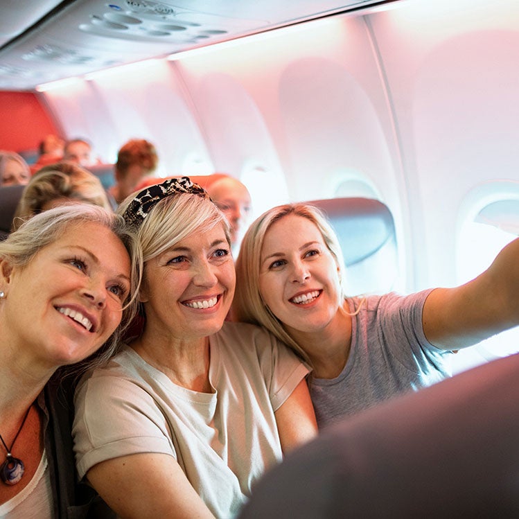 Drei Frauen, die im Flugzeug ein Selfie machen
