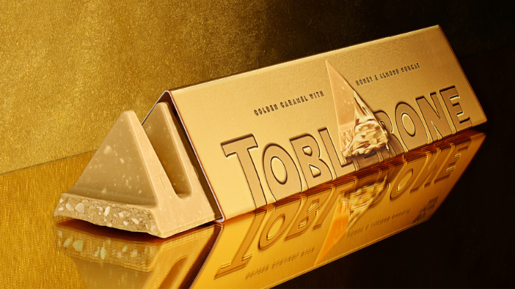 Opened Golden Toblerone Bar sitting on gold surface