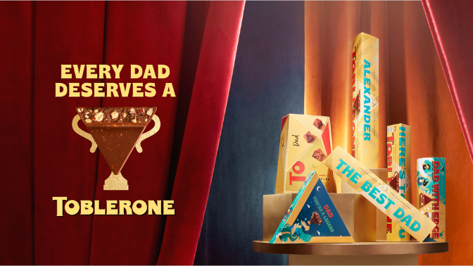 Triangle of Toblerone posing as a superhero in front of a red curtain with bars of Toblerone next to it, every dad deserves a Toblerone written in gold above and below it.