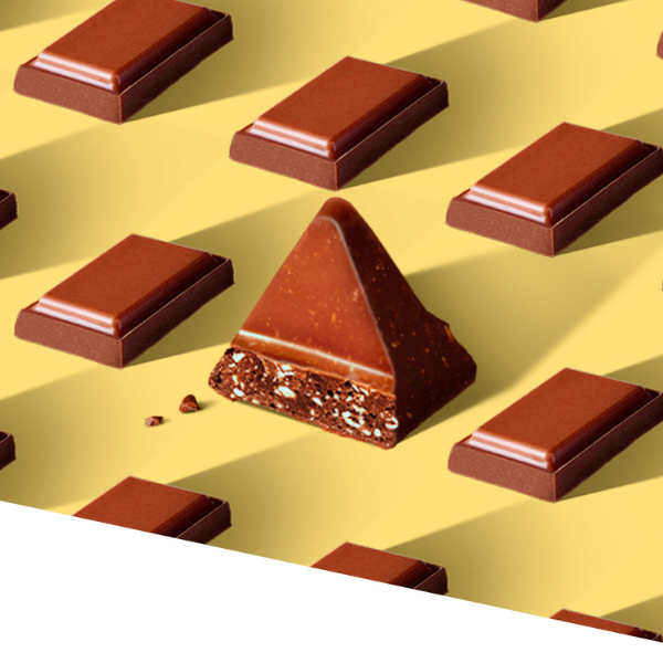 One piece of Triangle shaped chocolate surrounded by lined up rectangle shaped chocolates.