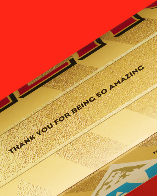 Close up of one side of a personalised Toblerone reading 'Thank You For Being So Amazing' on Red Background.
