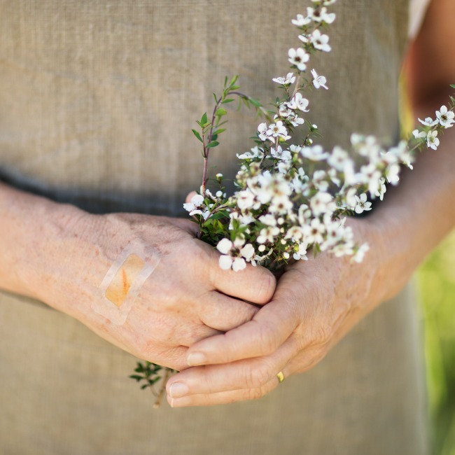 A woman holding white flowers in her hands.