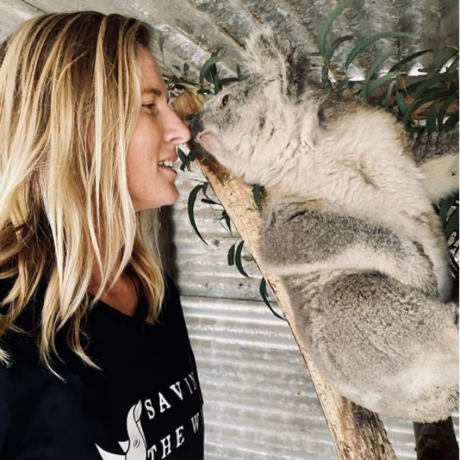 A woman touching noses with a rescued koala. Comvita Manuka Honey is helping Australian Wildlife affected by bushfires.