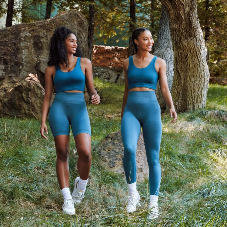 Two female models in teal sportswear collection