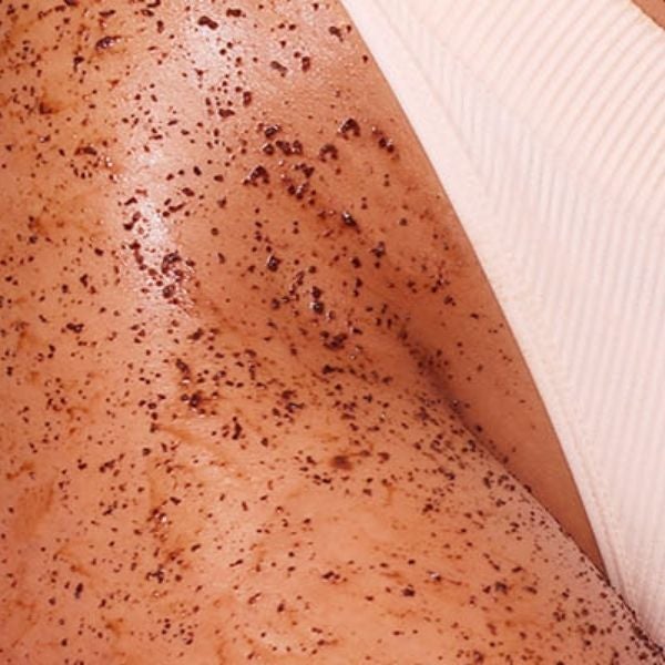 Closeup of women's leg with coffee scrub applied