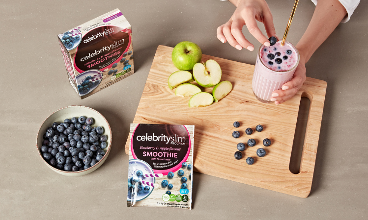 Celebrity Slim Blueberry and Apple Flavour Smoothie with blueberries and apple on a chopping board
