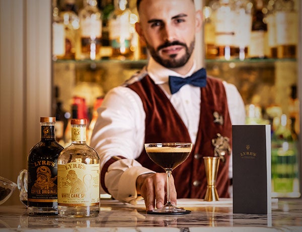 A bartender behind the bar serving cocktail