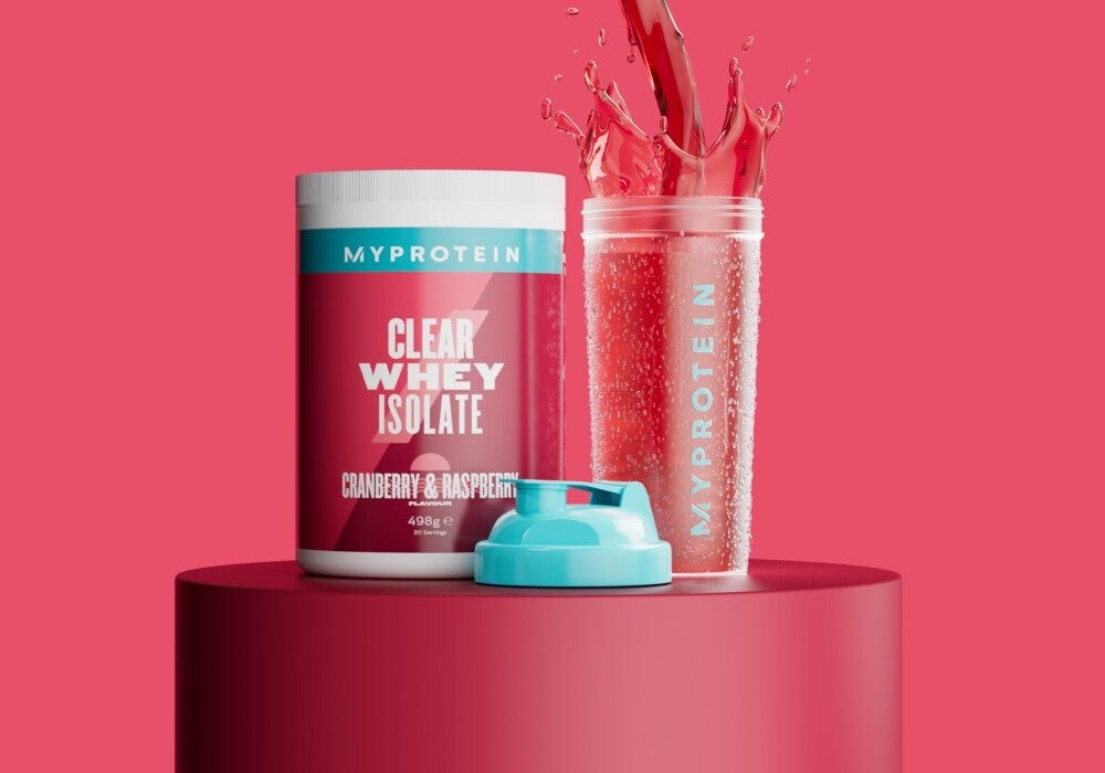 The clear protein starter pack on a podium in flavour cranberry & raspberry, next to a Myprotein branded shaker.
