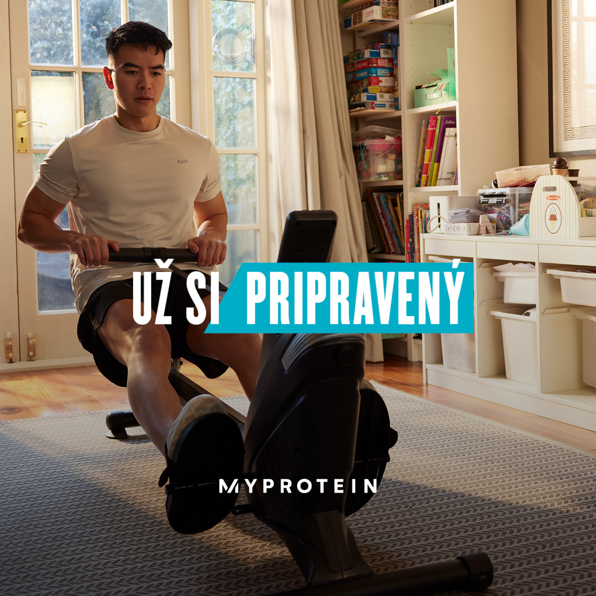 A man workout out on a rowing machine at home with the words 'You're Already Ready - MYPROTEIN' overlaying.