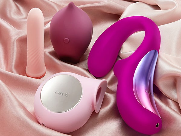 Four sex toys lay on a silk cloth