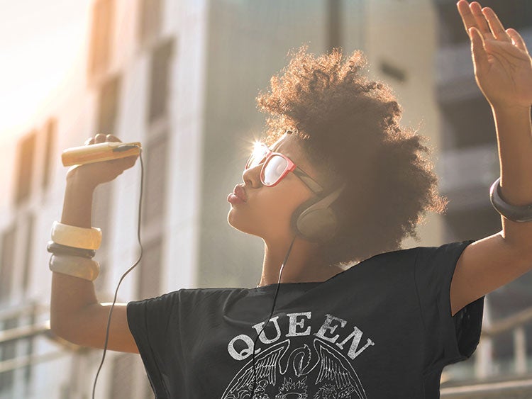 Woman dancing outside with her walkman in a Queen t-shirt