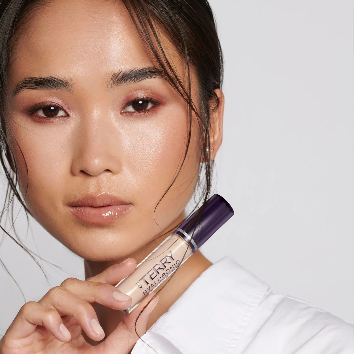 Model holding the Hyaluronic Serum Concealer