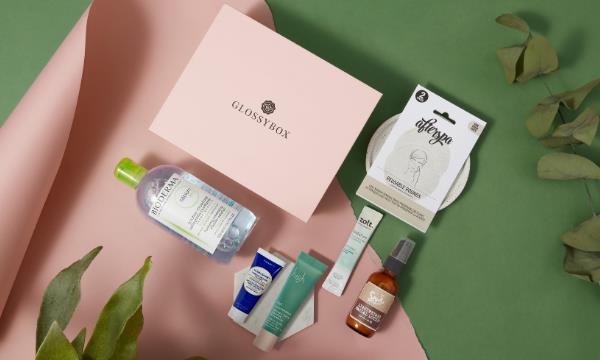 Pink GLOSSYBOX surrounded by green leaves and 6 beauty products