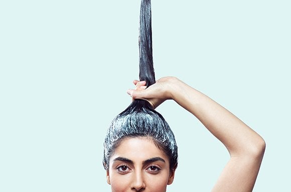 woman applying exfoliating scalp scrub to her scalp
