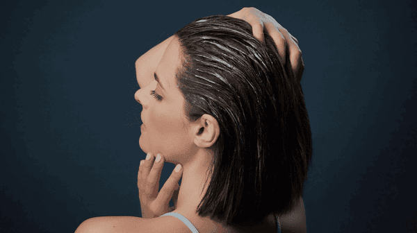 woman applying exfoliating scalp scrub to her scalp