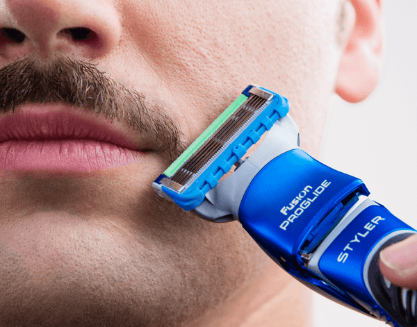 Man trimming moustache with Gillette Styler.