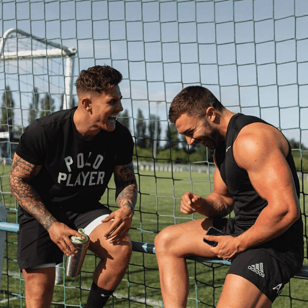 two athletes laughing on football pitch